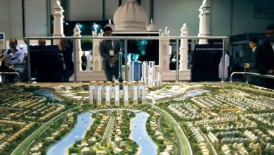 Visitors look at the Falcon city model during the Cityscape real estate exhibition in Dubai