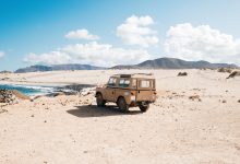 shot of an off-road car standing in a wild area by a small lake