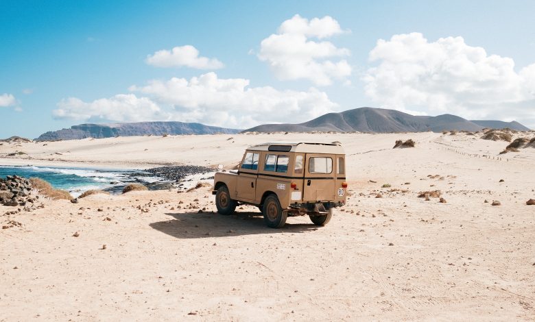 shot of an off-road car standing in a wild area by a small lake