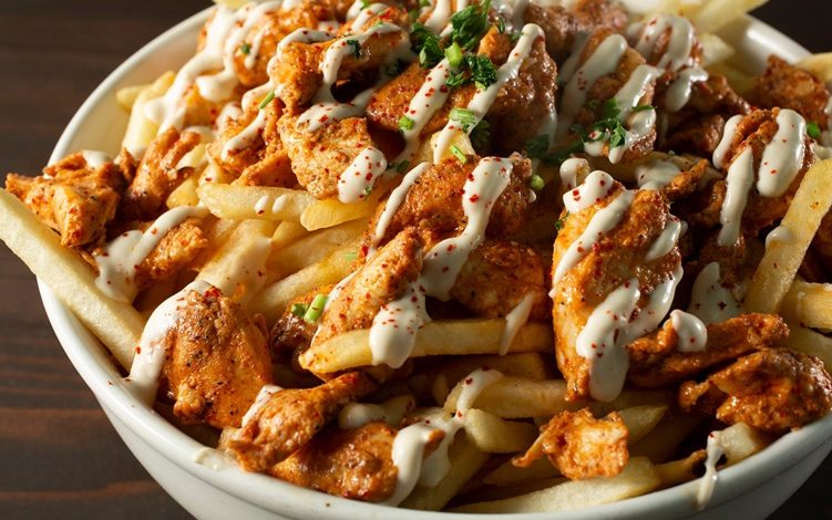 A,Closeup,View,Of,A,Bowl,Of,Chicken,Shawarma,Fries.